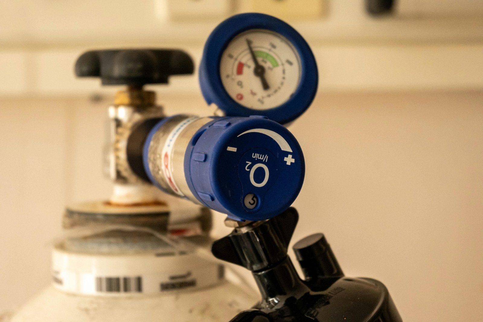 Detailed view of an oxygen tank with a pressure gauge, showcasing medical equipment usage.