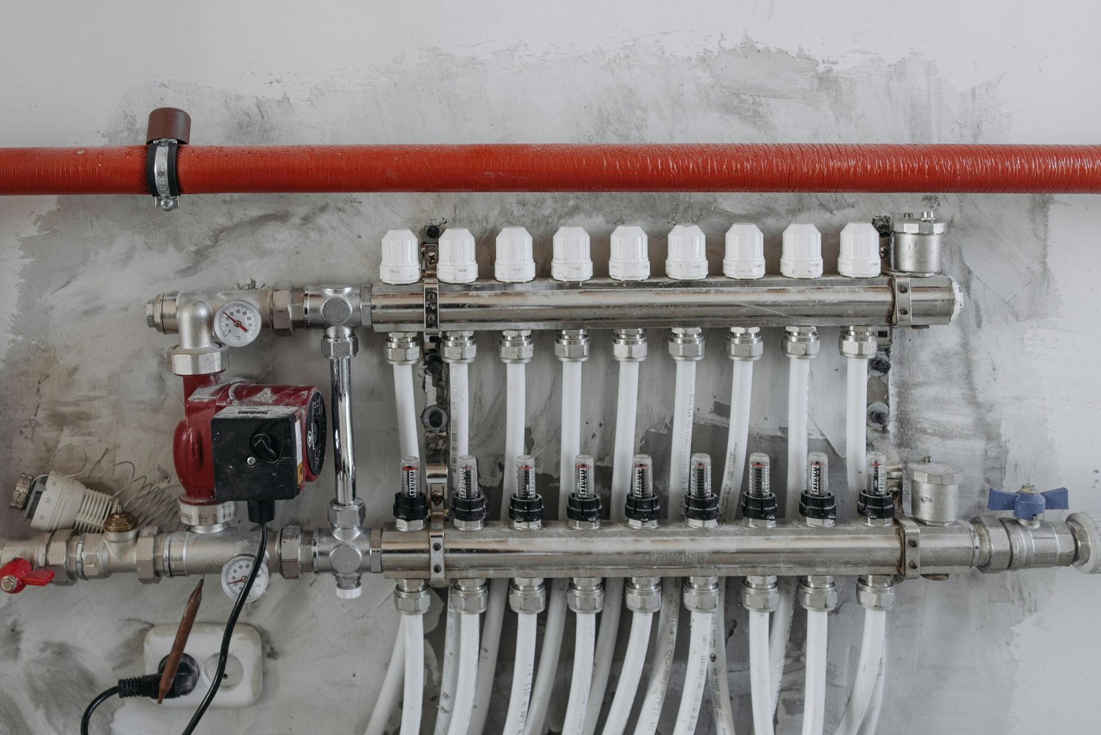 A close-up view of an industrial manifold with pressure gauges and connected steel pipes.